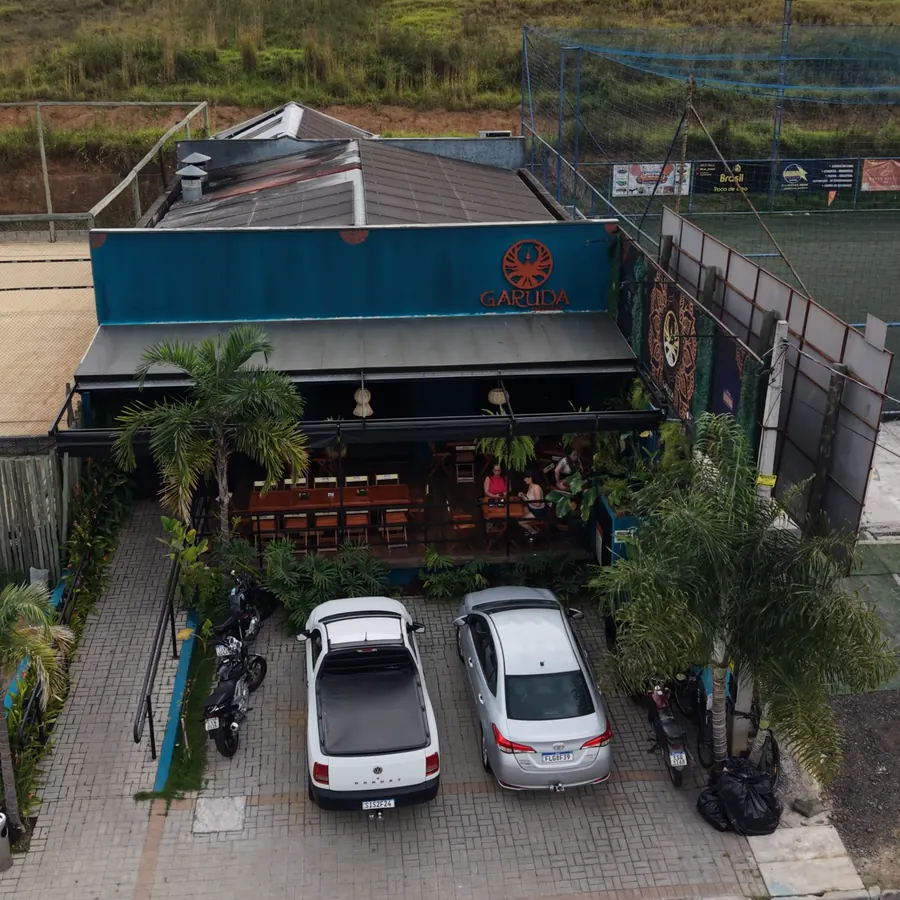 Vista aérea do Garuda Gastrobar de dia, com a fachada inteira e o letreiro, em Guaratinguetá