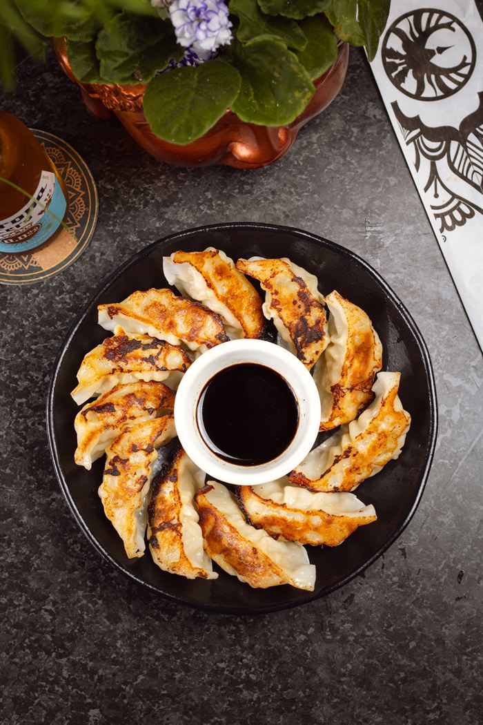 Gyoza selado na chapa arrumado em círculo com shoyu no centro