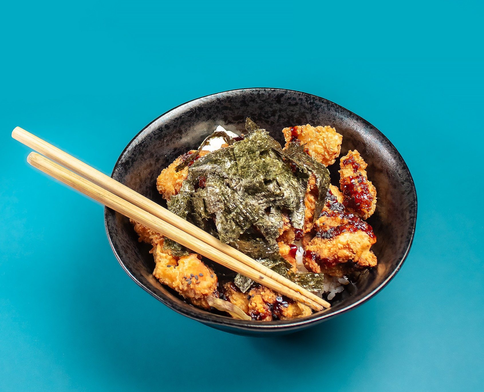 Molho sendo servido sobre o karaguê, frango frito japonês